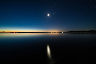 Scenic view of lake against clear sky at night