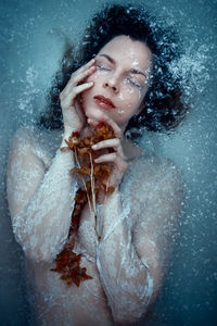 Icy flower - selfportrait - woman in icy water holding a flower in her hands