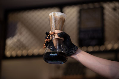 Close-up of hand holding coffee cup