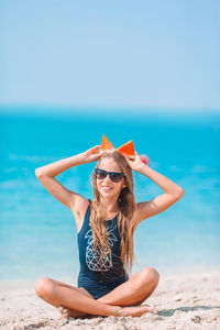 Woman wearing sunglasses on beach against sky