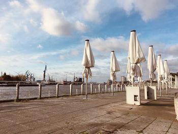 Panoramic view of chairs on beach against sky