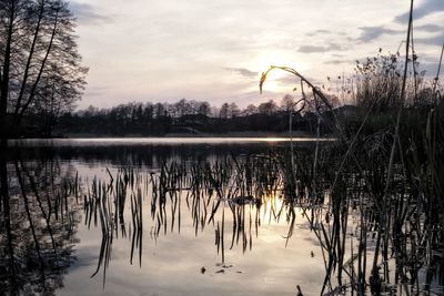 Scenic view of lake against sky at sunset