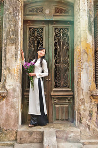 Rear view of woman standing against historic building