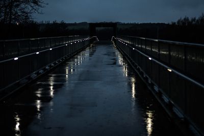 Bridge over river against sky at night