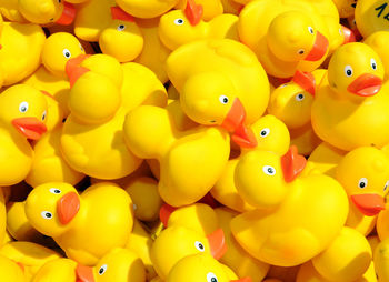 A bunch of yellow plastic ducks with red beaks, toy animals