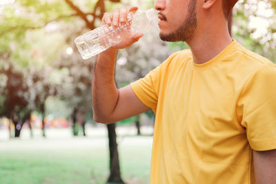 Midsection of man drinking water