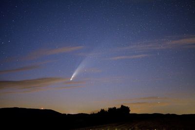 Low angle view of vapor trails in sky at night