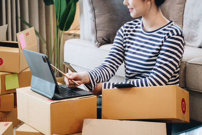 Midsection of woman using laptop at home