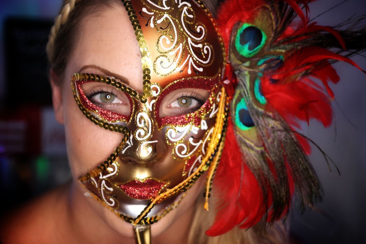 CLOSE-UP PORTRAIT OF MASK ON MULTI COLORED FEATHERS