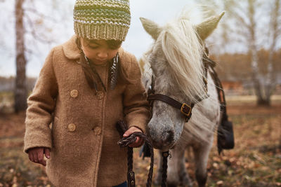 Little girl walking with pony