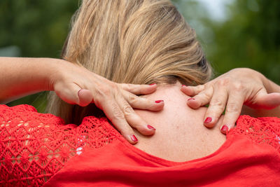 Close-up portrait of woman with red hands