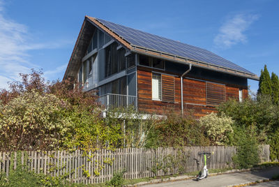 Germany, bavaria, munich, electric push scooter left in front of modern passive house equipped with solar panels