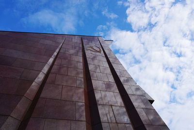 Low angle view of modern building against cloudy sky