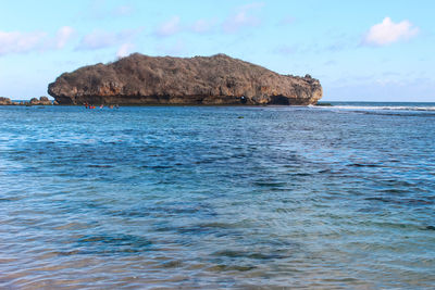 Scenic view of rocks in sea against sky