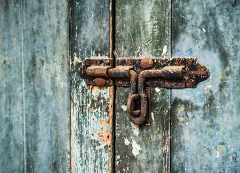 Close-up of rusty latch on closed door
