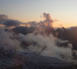 Smoke emitting from volcanic mountain against sky during sunset