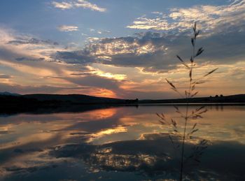 Scenic view of lake against sky at sunset