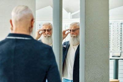 Men with reflection of people in mirror