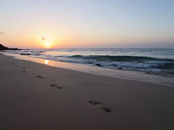 Scenic view of beach against sky during sunset