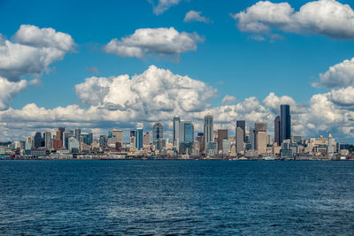 City skyline by sea against sky