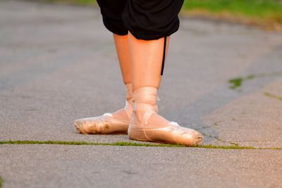 Low section of man wearing shoes on footpath