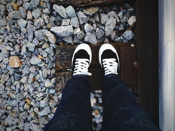 Low section of person standing on railroad tie