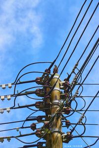 Low angle view of cables against blue sky during sunny day