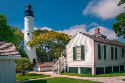 Old lighthouse and its surroundings of old,white, wooden houses and green trees in key west, florida