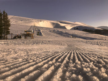 Scenic view of land against clear sky during winter