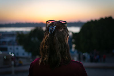 Rear view of woman against sky during sunset