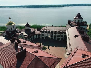 High angle view of buildings by sea against sky