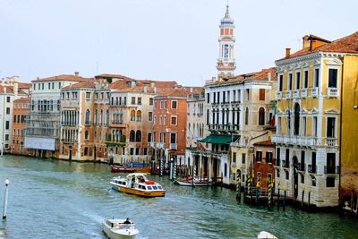 Boats in canal amidst buildings in city