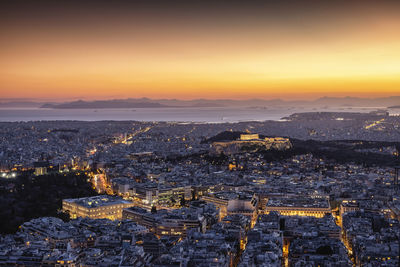 High angle view of illuminated cityscape against sky during sunset