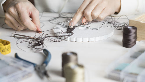 High angle view of woman working with thread on table