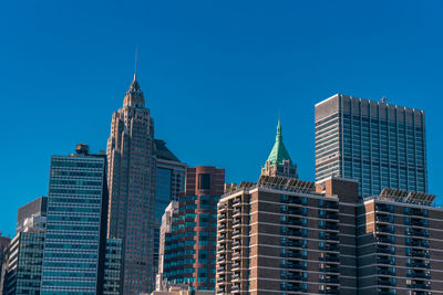 Low angle view of modern buildings against clear blue sky