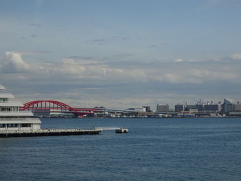 Bridge over river against sky in city