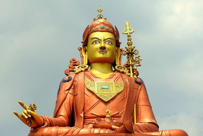 Low angle view of statue against temple against sky