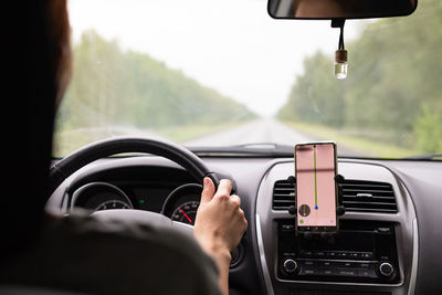 Cropped hand of man driving car