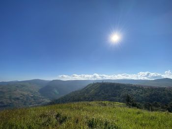 Scenic view of mountains against bright sun