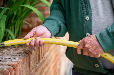 Midsection of man holding tape measure