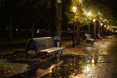 Empty bench in park during rainy season