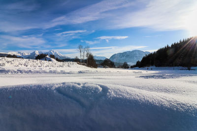 Snow covered land and mountains against sky