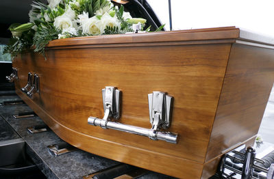 Closeup shot of a funeral casket or coffin in a hearse or chapel or burial at cemetery
