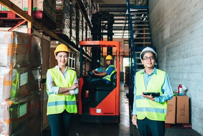 Portrait of smiling engineers standing at warehouse