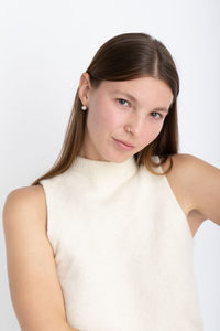 Portrait of young woman against white background