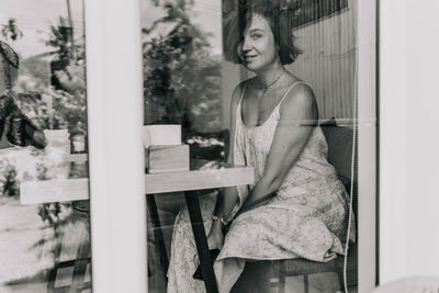 Young woman sitting on chair in cafe 