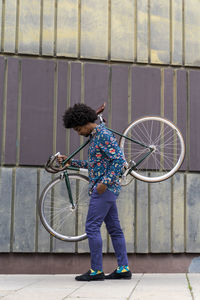 Stylish man carrying bicycle in the city