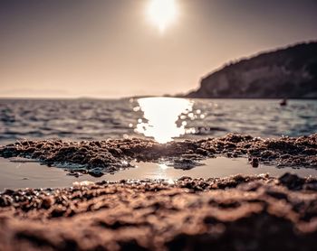 Surface level shot of sea against sky during sunset