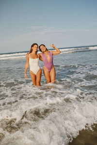 Full length of young woman in bikini standing at beach