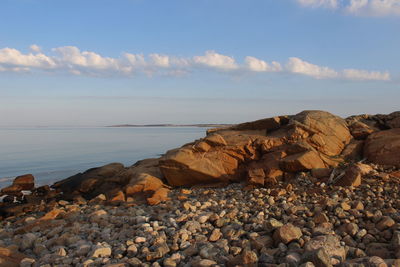 Rocks on beach against sky